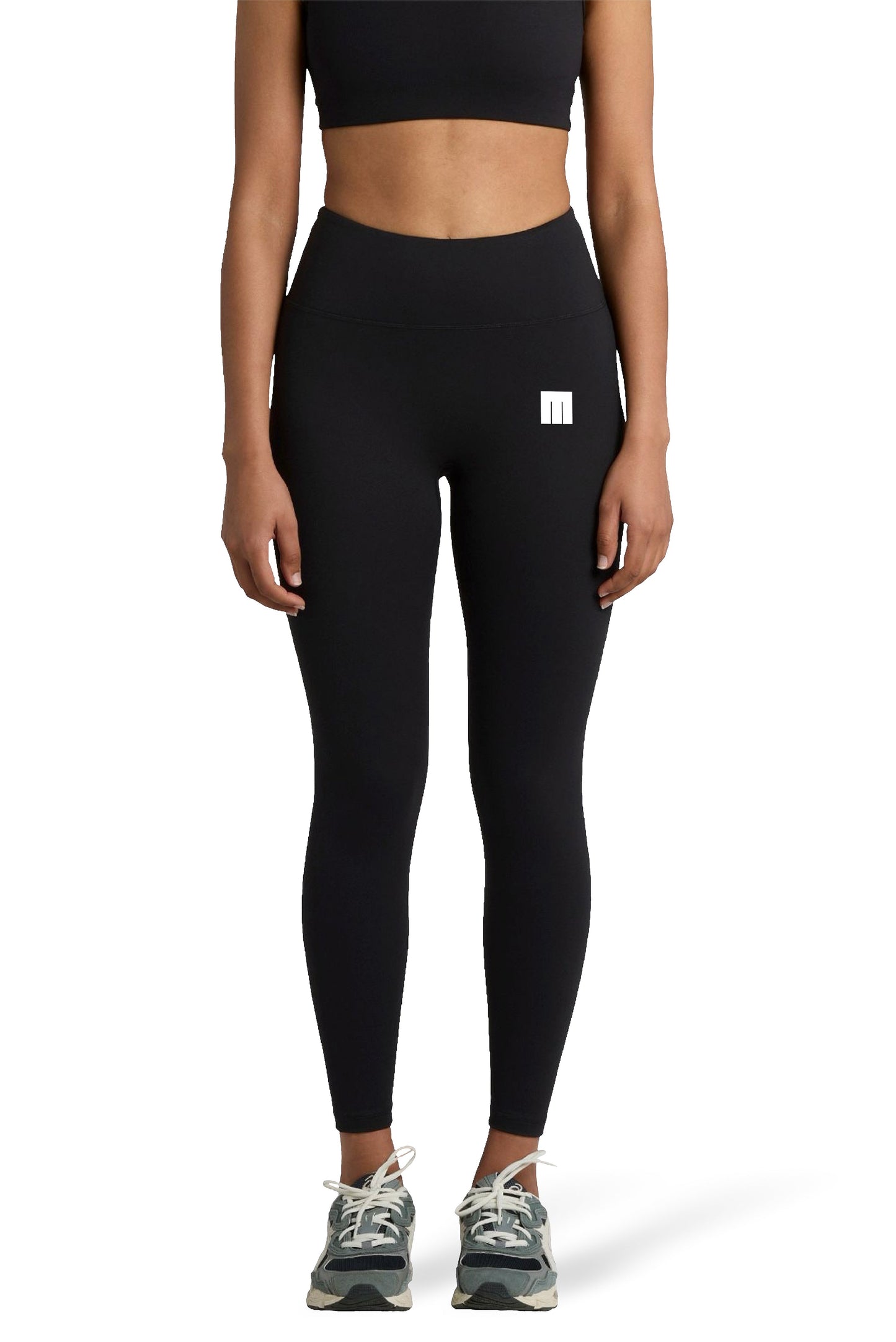 Person wearing black leggings with a small white logo on a white background