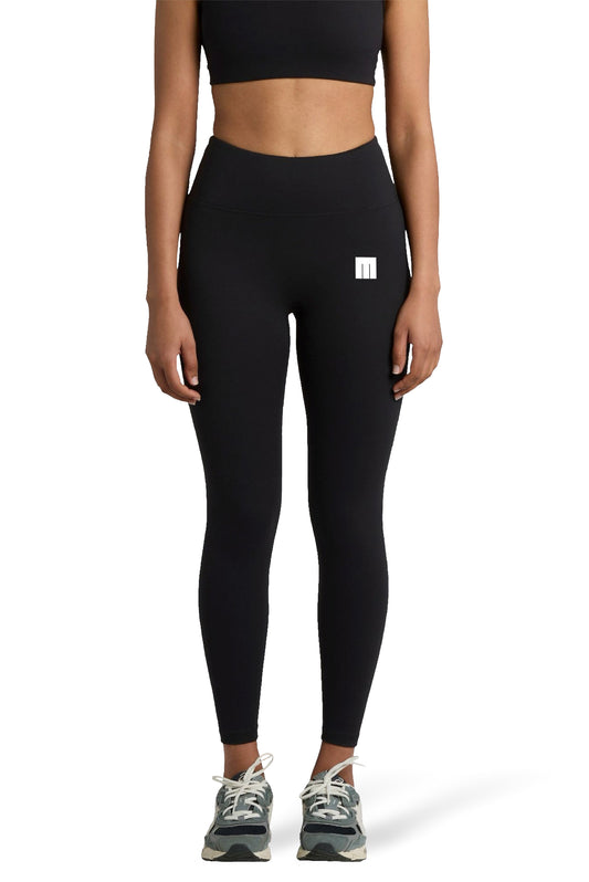 Person wearing black leggings with a small white logo on a white background