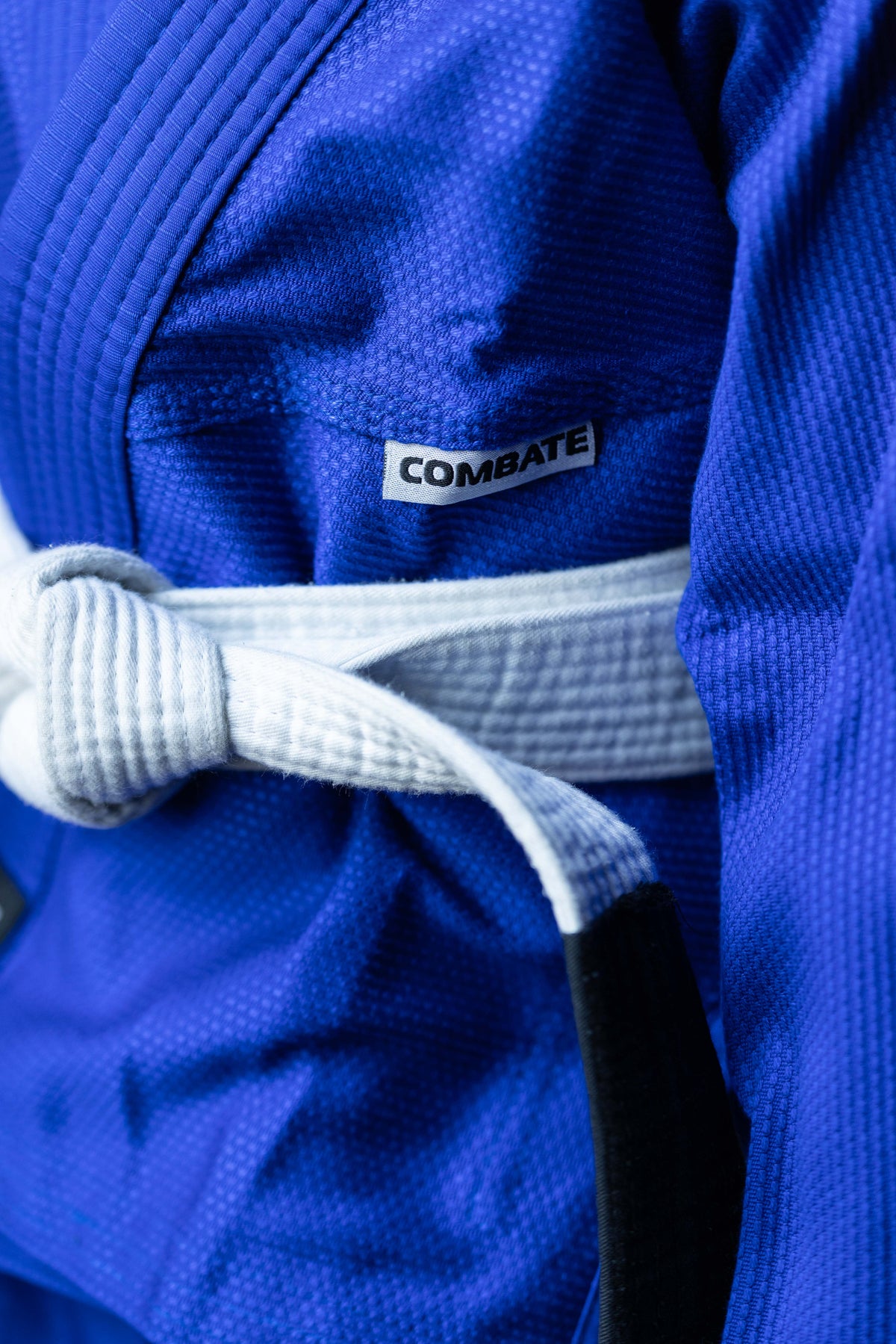 close up of a blue martial arts gi with Combate tag visible. 